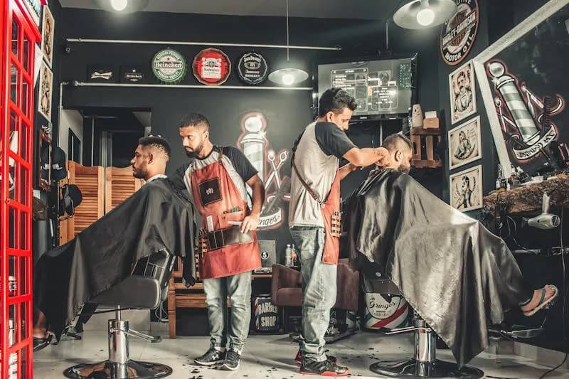 Interior de barbería con dos barberos trabajando